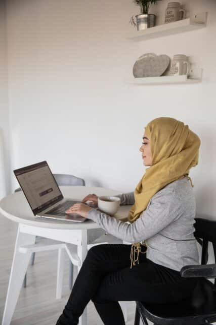 image of a woman completing a survey on her laptop at home